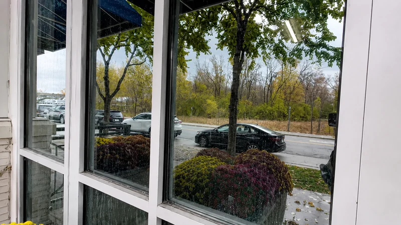 Large residential windows with visible water streaks and spotting