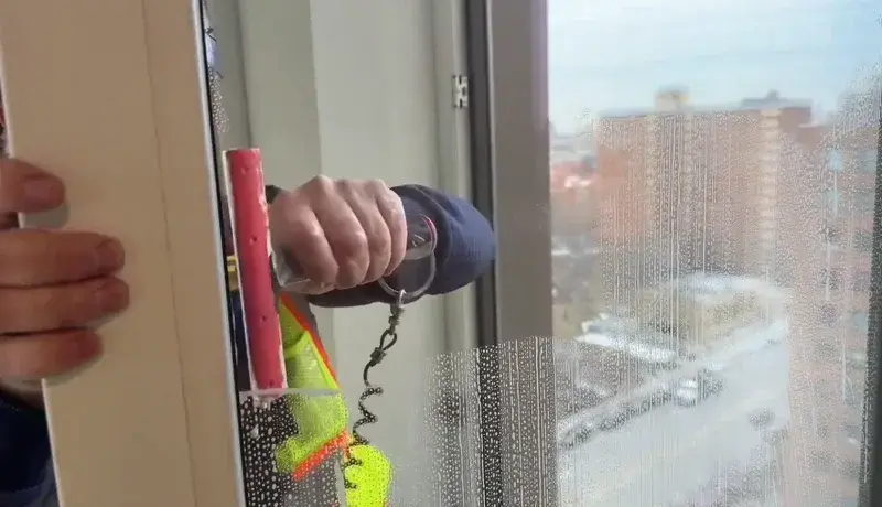 Exterior window being cleaned during the final stages of a construction project